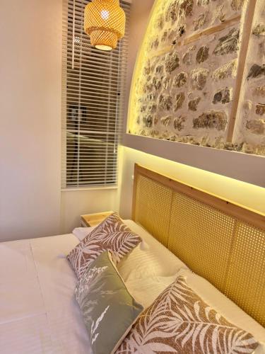 a bed with two pillows on it in a bedroom at Old Town Suites Muradie in Vlorë