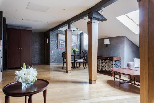 a living room with a table and a dining room at Eurostars Metropole in Rīga