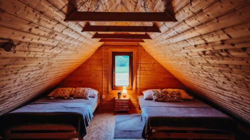 a attic room with two beds and a window at Polna Przystań 694-272-463 in Uherce Mineralne (7)