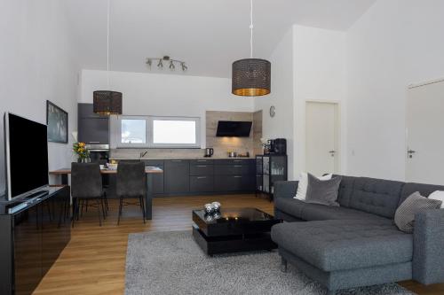 a living room with a couch and a table at Chalet Am Ried in Bad Wurzach