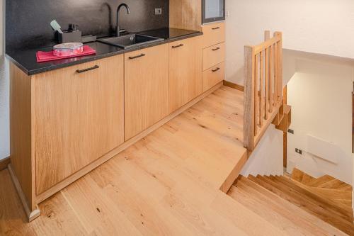 a kitchen with wooden cabinets and a wooden floor at Nest-home in front to Mont Blanc in Courmayeur