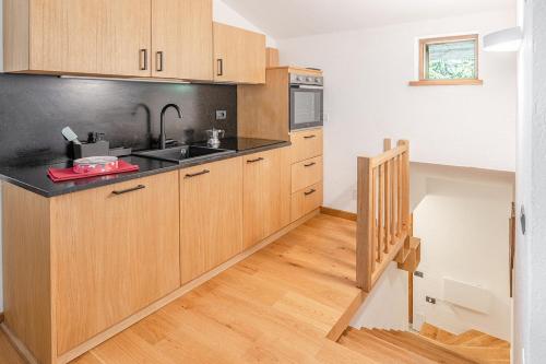 a kitchen with wooden cabinets and a staircase at Nest-home in front to Mont Blanc in Courmayeur