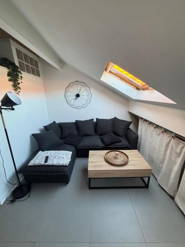 a living room with a black couch and a table at Cosy Rooftop Studio Nice Centre in Nice