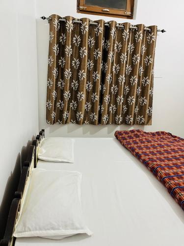 a room with a bed and a window with a curtain at Mangalayatan Home Stay Ayodhya in Faizābād