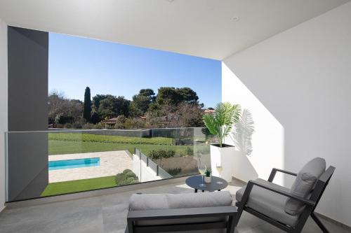 a living room with a large window with a pool at Valbrione - Luxury Rooms & Suites in Valbandon