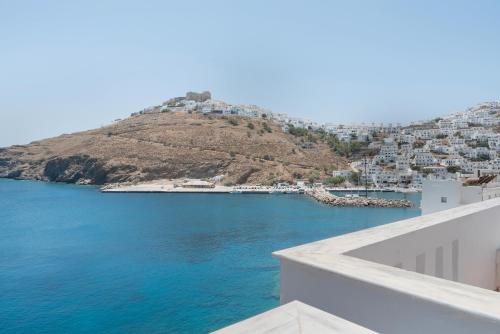 a view of the ocean and a hill with houses at Caldera Studios in Astypalaia Town