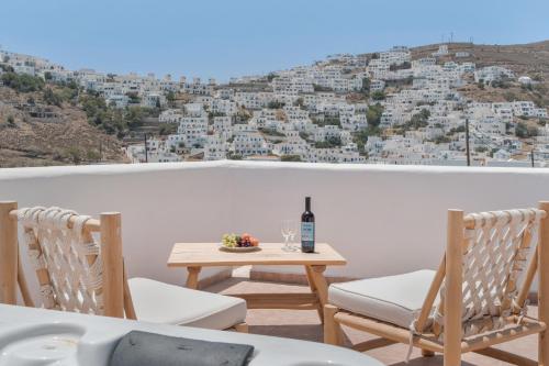 a table with a bottle of wine and two chairs at Caldera Studios in Astypalaia Town