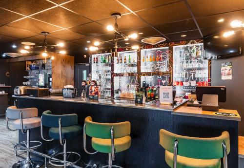 バッス・ユッツにあるB&B HOTEL Thionville Yutz Route du Luxembourgのレストランの緑の椅子付きのバー
