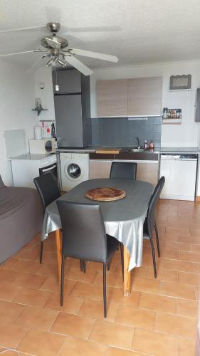 une cuisine et une salle à manger avec une table et des chaises dans l'établissement Front de Mer T2, au Barcarès