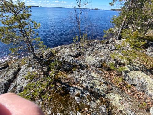 a person pointing at a mountain with a view of a lake at Lammassaari in Savonlinna