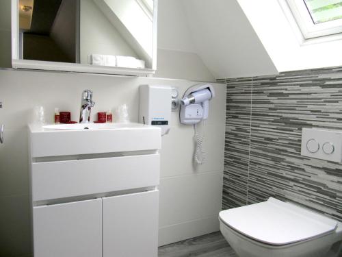 a bathroom with a toilet and a sink at Hôtel de la Grotte in Aix-les-Bains