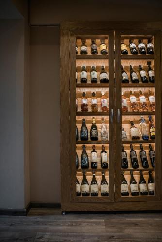 a wooden cabinet filled with lots of bottles of wine at Entheos Private Villa Fiskardo Kefalonia Greece in Fiskardho
