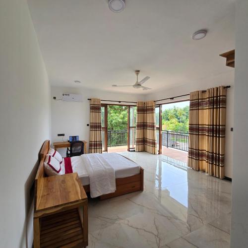 a bedroom with a bed and a balcony at Waypoint Resort and Apartments in Hikkaduwa