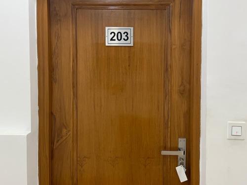 a wooden door with a sign on it at The Shalam Resort श्रीकृष्ण शरणं मम in Lansdowne