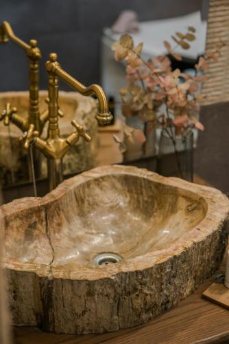 a sink with a gold faucet and a vase of flowers at Entheos Private Villa Fiskardo Kefalonia Greece in Fiskardho