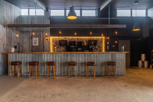 a bar with five bar stools in a room at Hótel Blönduós in Blönduós