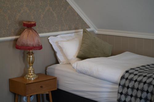 a bed and a lamp on a night stand next to a bed at Hótel Blönduós in Blönduós