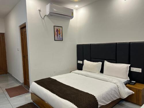 a bedroom with a large bed with a black headboard at The Shalam Resort श्रीकृष्ण शरणं मम in Lansdowne