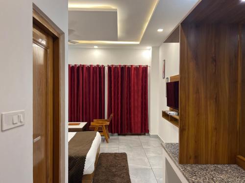 a hotel room with a bed and a red curtain at The Shalam Resort श्रीकृष्ण शरणं मम in Lansdowne