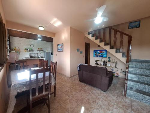 a living room with a couch and a staircase at Casa ampla Churrasqueira Natureza Maricá RJ in Maricá