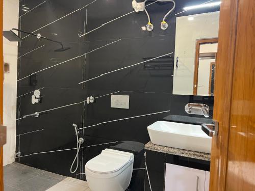 a black bathroom with a toilet and a sink at The Shalam Resort श्रीकृष्ण शरणं मम in Lansdowne