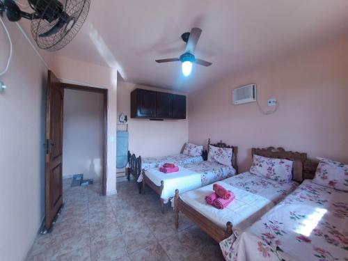 a living room with two beds and a couch at Casa ampla Churrasqueira Natureza Maricá RJ in Maricá