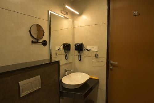 a bathroom with a sink and a mirror at Hotel Sahana Grand in Tirupati