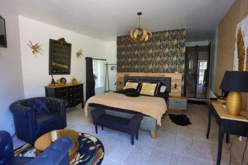 a bedroom with a bed and a blue chair at Le Clos Saint Fiacre in Carentoir