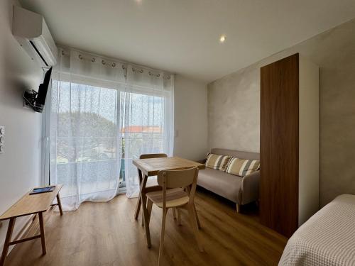 - une chambre avec une table, un lit et une fenêtre dans l'établissement Beau Soleil by JB l Port la Nouvelle, à Port-la-Nouvelle