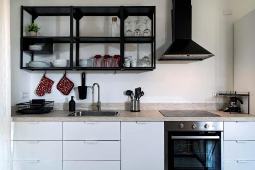 a kitchen with white cabinets and a sink at Villa Elisabetta Apartments in Pula