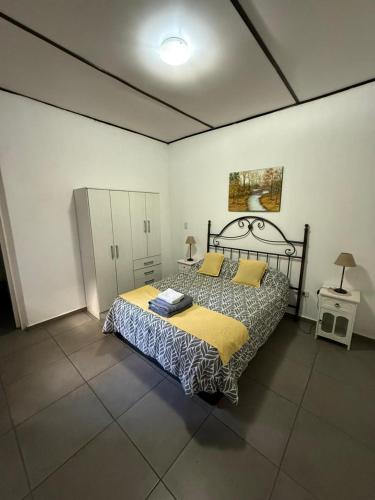 a bedroom with a large bed with a yellow blanket at Departamento Mis Nonos 4 in Mendoza