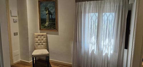 a chair sitting next to a window with a curtain at Hotel Foresteria Baglio Della Luna in San Leone