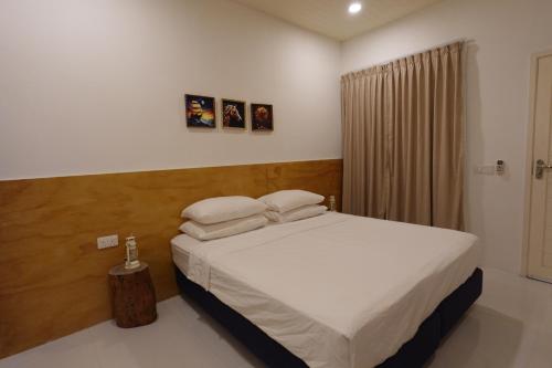a bedroom with a bed with white sheets and pillows at Stay Kora in Thinadhoo
