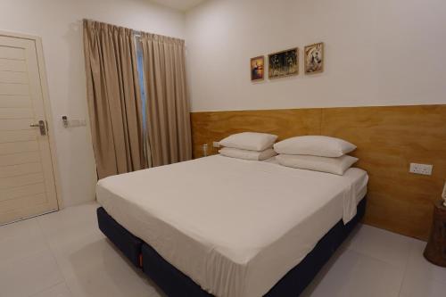 a bedroom with a bed with white sheets and pillows at Stay Kora in Thinadhoo