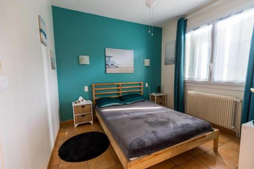Un dormitorio con una cama y una pared azul. en Gite west landes, en Onesse-et-Laharie