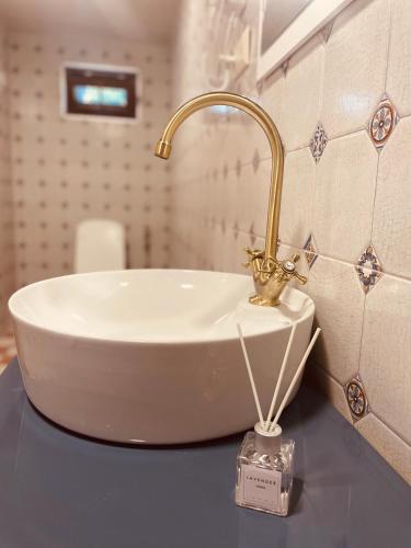 a bathroom sink with a gold faucet on a counter at House of Warmth in Bagdatʼi