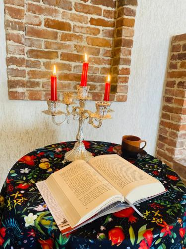 an open book on a table with two candles at House of Warmth in Bagdatʼi