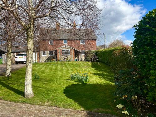 a large brick house with a yard with flowers at Stylish Cabin in East Sussex near Newhaven ferry in Newhaven