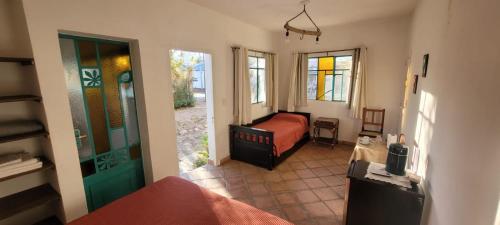 Un dormitorio con una cama y una puerta a una habitación. en El Churqui, en Cafayate