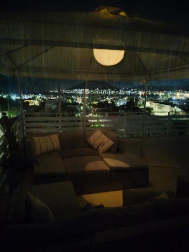 a couch in a room with a view of a city at Bay view in Salamís