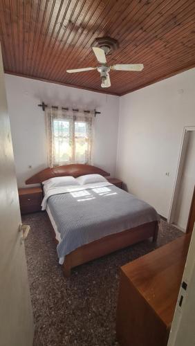 ein Schlafzimmer mit einem Bett und einem Deckenventilator in der Unterkunft Seaside House in Paralia Dionisiou