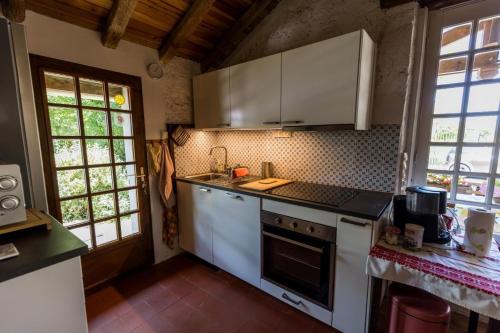 a kitchen with white cabinets and a stove top oven at Gite des granges in Fargues
