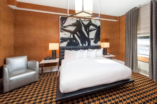 a bedroom with a white bed and a chair at Ameritania at Times Square in New York