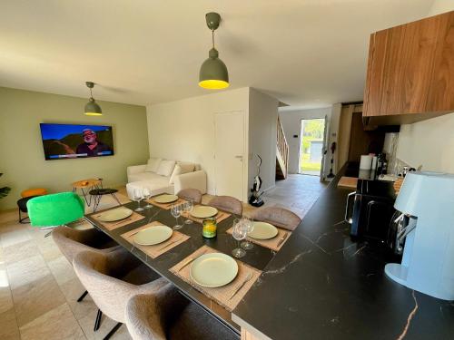 - un salon avec une table à manger et des chaises dans l'établissement Villa Climatisée 8 Pers, 4 chambres, 3 Sdb, à Saubion