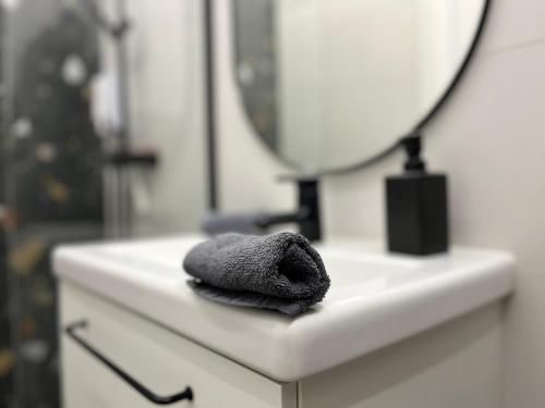 a towel sitting on a bathroom sink in front of a mirror at Modern stúdió a Belváros közepén parkolóval- Kata stúdióapartman in Győr