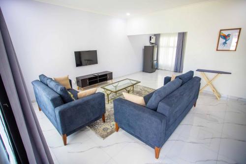 a living room with two blue couches and a table at Longhorn Ibex Apartments in Lusaka
