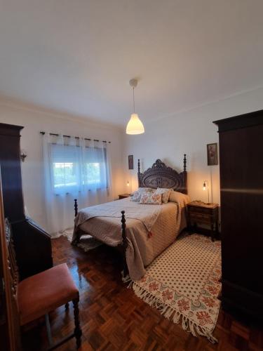 una camera da letto con un letto grande e una finestra di Zinha's Guest House a Moledo