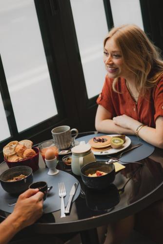 Una donna seduta a tavola che mangia. di Hôtel Belleval a Parigi