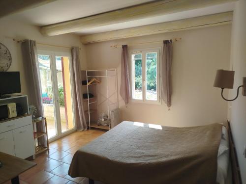 une chambre avec un lit et deux fenêtres dans l'établissement Studio 25m2 avec piscine proche Iter et Cadarache, à Valensole
