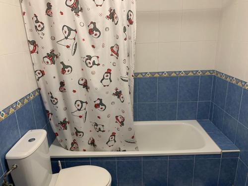 a bathroom with a shower curtain with a toilet at Apartamentos La Almadraba 1-5 in El Pozo del Cabo